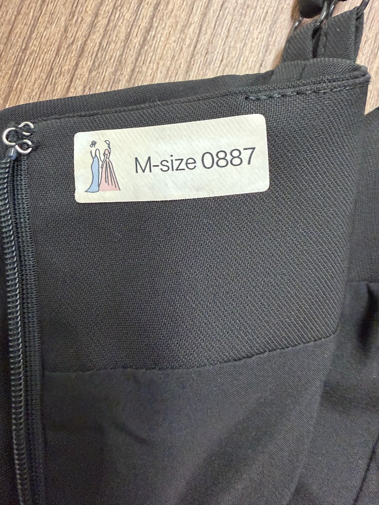 ドレスの内側に貼られたIDタグの見本写真。「M-size 0887」と印字されている